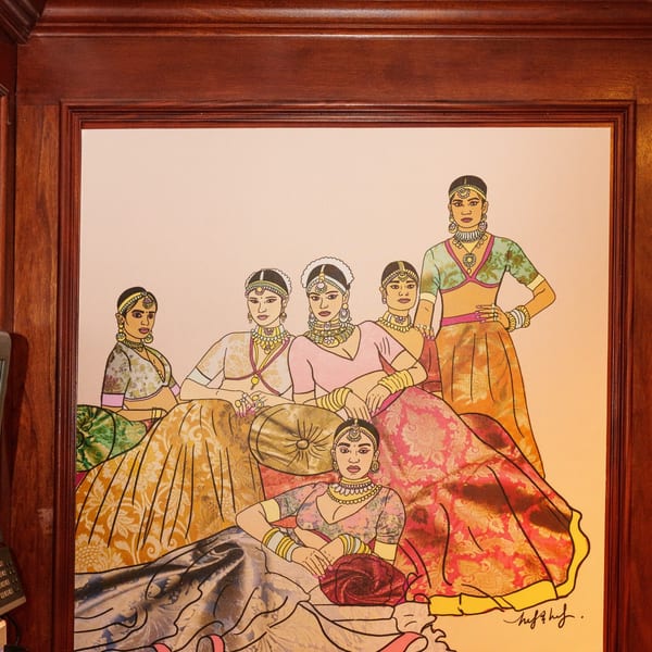 A framed painting of six Indian women in traditional attire and jewelry, in various poses.