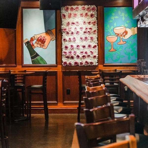 Curry Club's dining area with wooden paneling, bar seating, and three decorative wall panels.