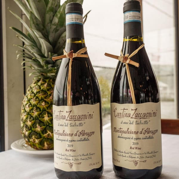Two bottles of Cantina Zaccagnini Montepulciano d'Abruzzo red wine next to a pineapple.