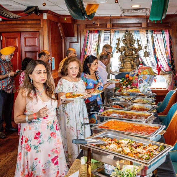 Guests at Curry Club's Indian buffet, serving themselves from an array of dishes.