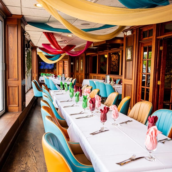 Long dining tables with colorful napkins and chairs in the Curry Club Indian restaurant.